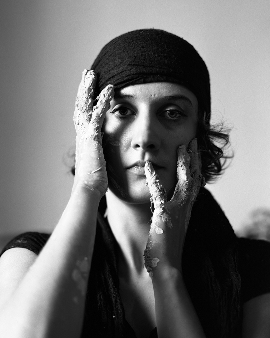 Portret artystki z gliną na rękach